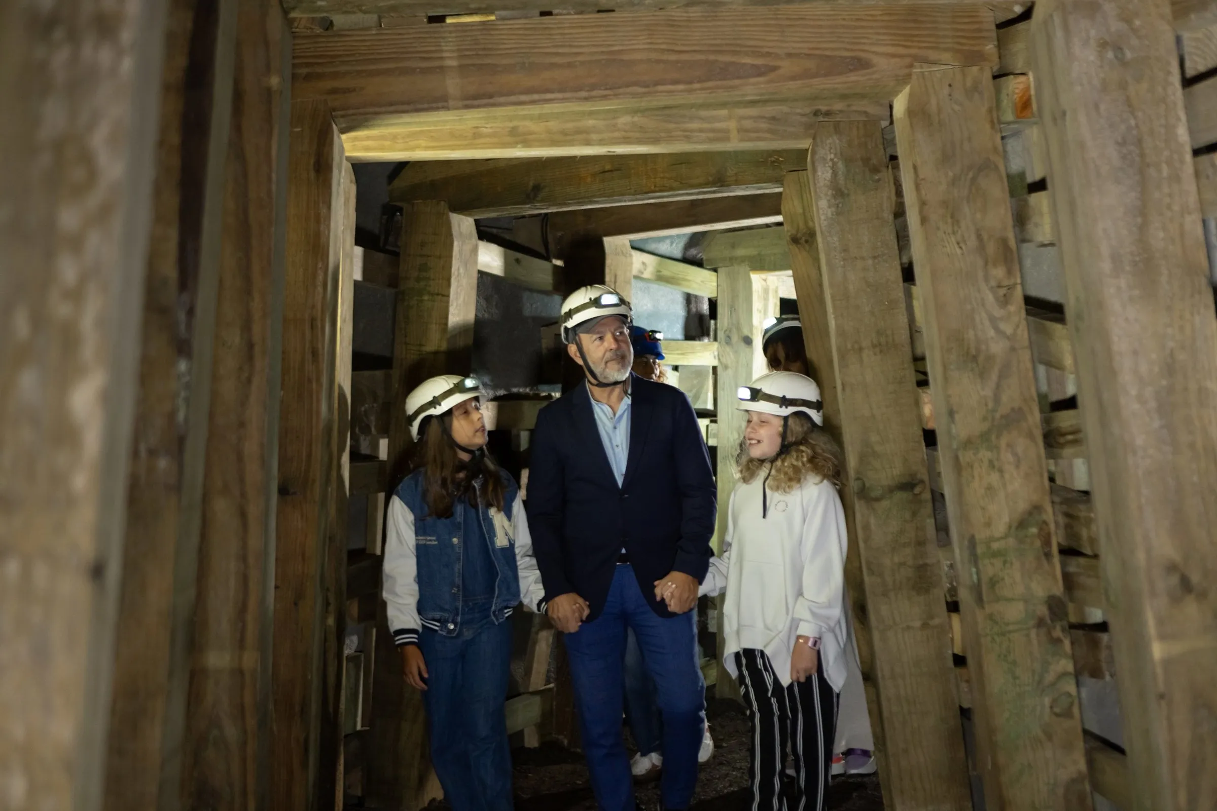 Visitantes con casco recorren una galería entibada