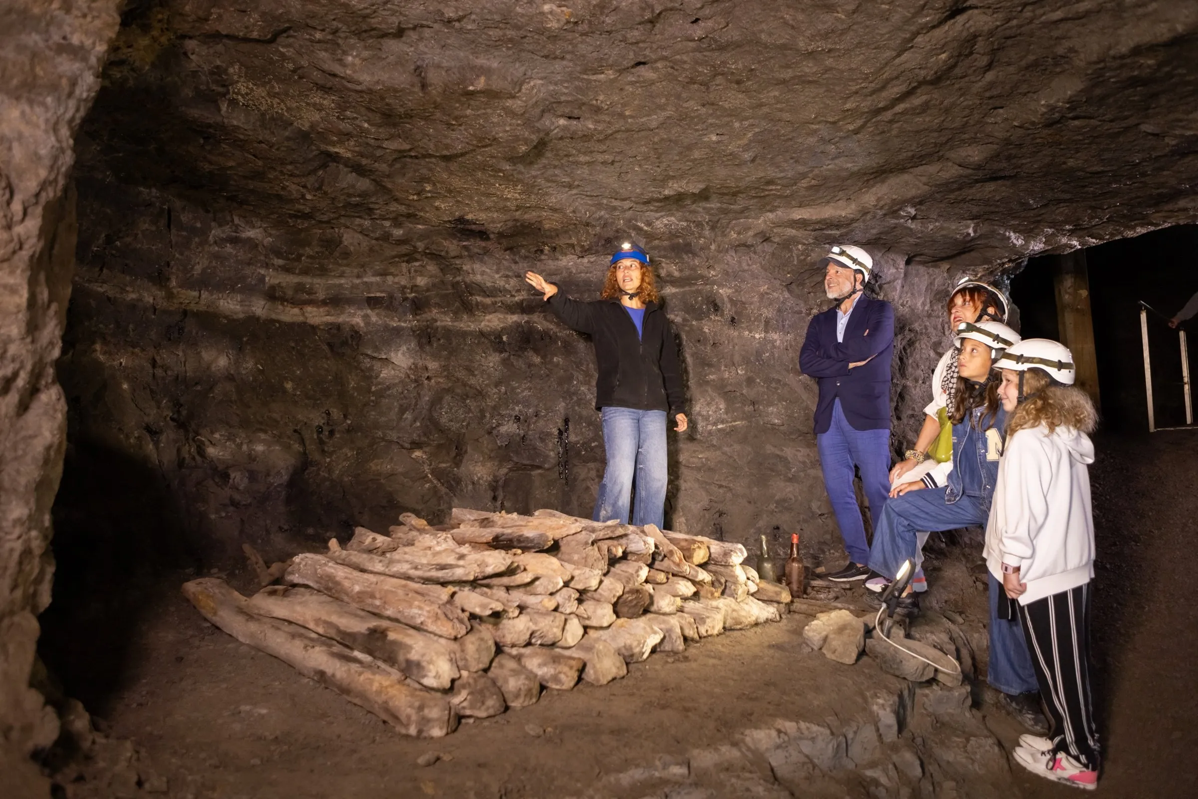 El guía explica junto a una pila de rocas de asfalto