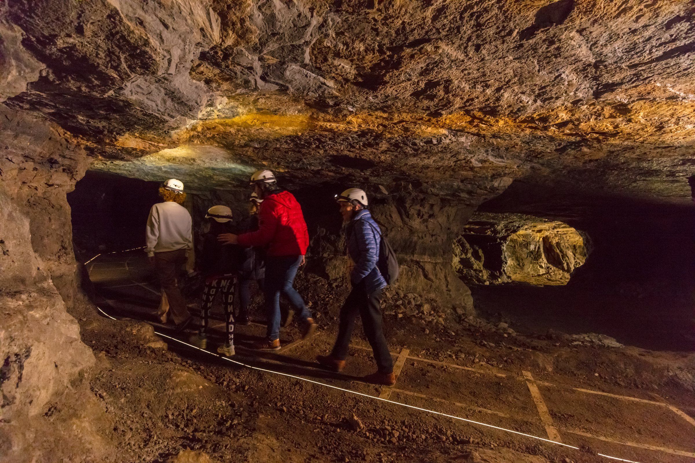Galería de Mina Lucía, con las paredes impregnadas de asfalto bajo la luz de las linternas